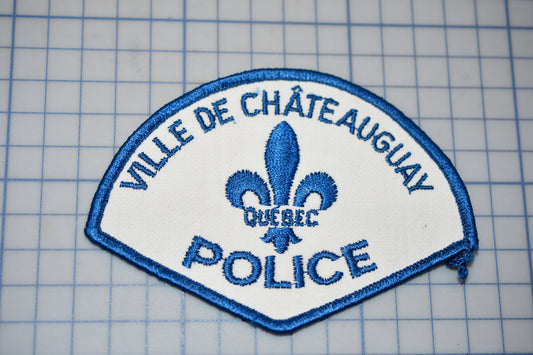 a police patch with a fleur de chateau on it