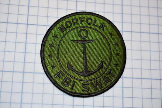 a patch with a green and black logo on it