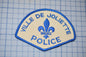 a police patch with a fleur de joliette on it