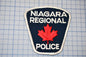 a lapel badge with a maple leaf on it