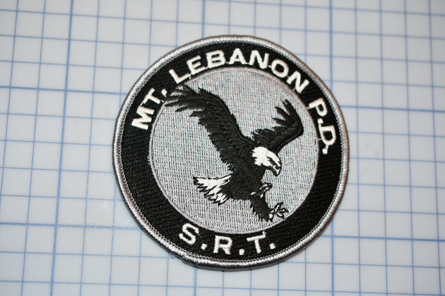 a white and black patch with an eagle on it