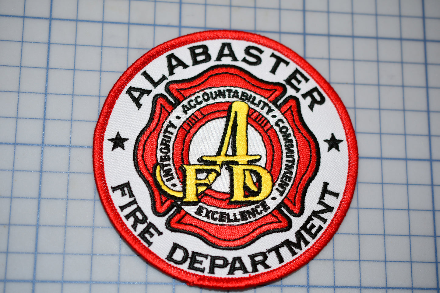 a red and white patch with a fire department logo