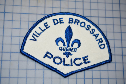 a police patch with a fleur de brosard on it