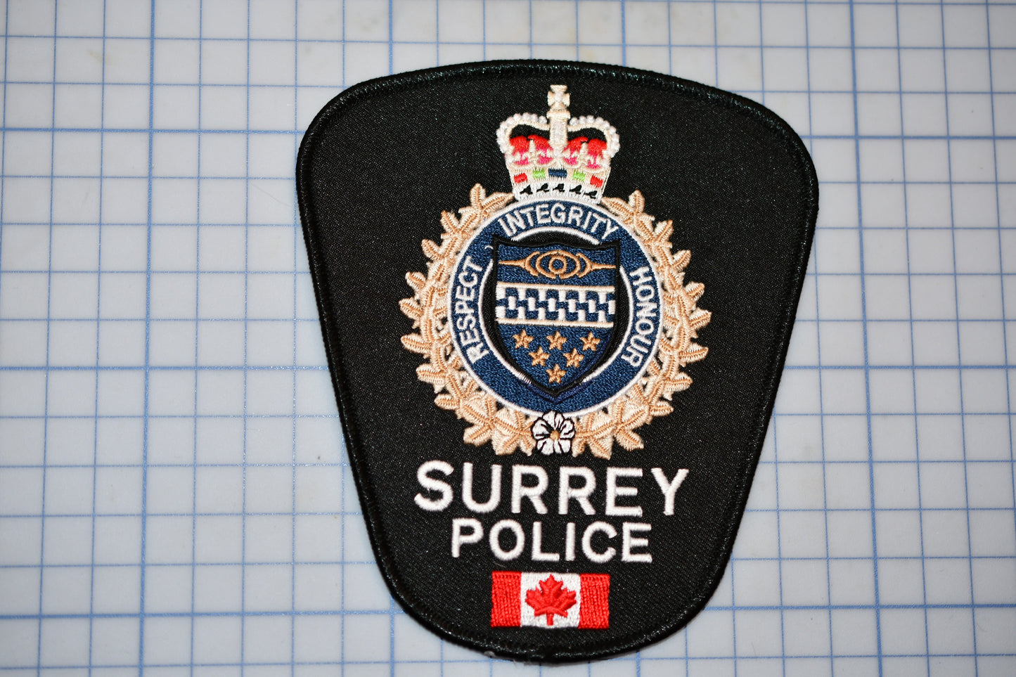 a surrey police badge on a piece of paper