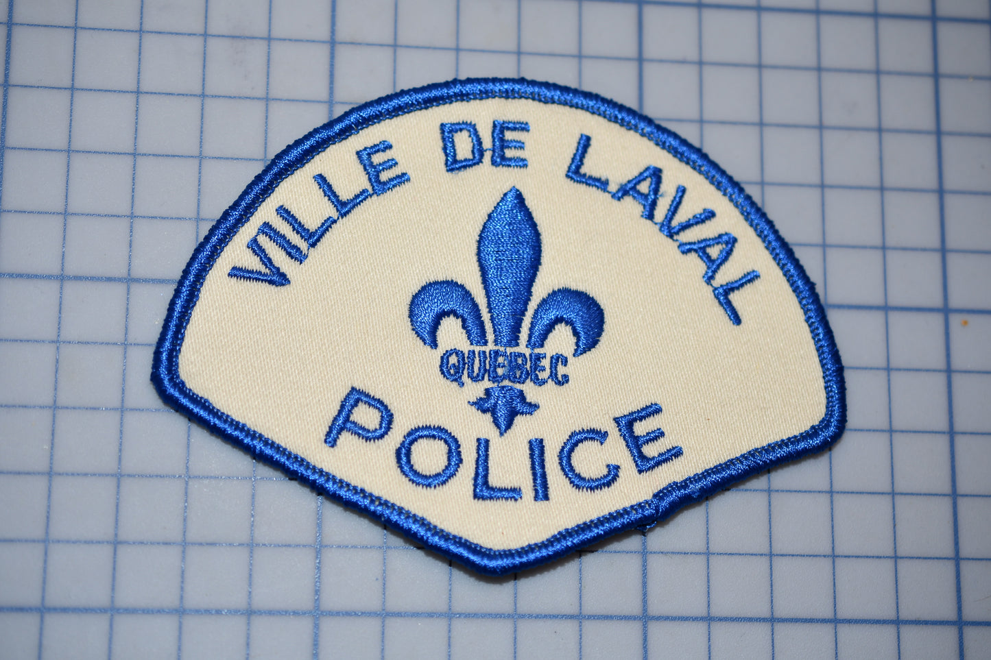 a blue and white police patch with a fleur de lavail on it