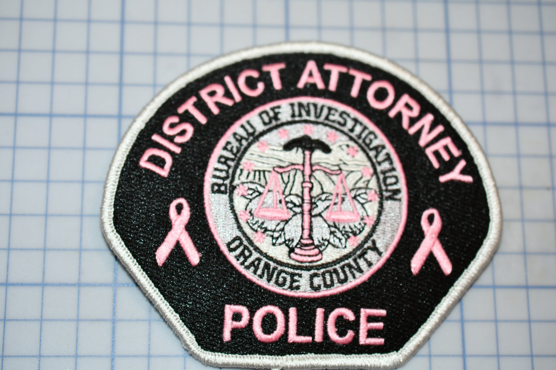 a patch with a pink ribbon on it