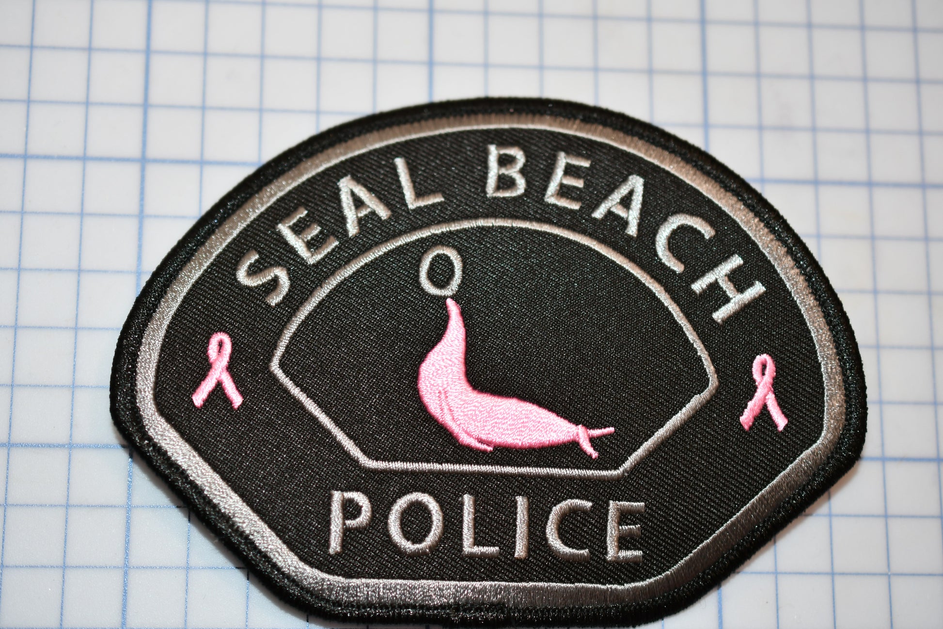 a patch with a pink bird on it that says seal beach police