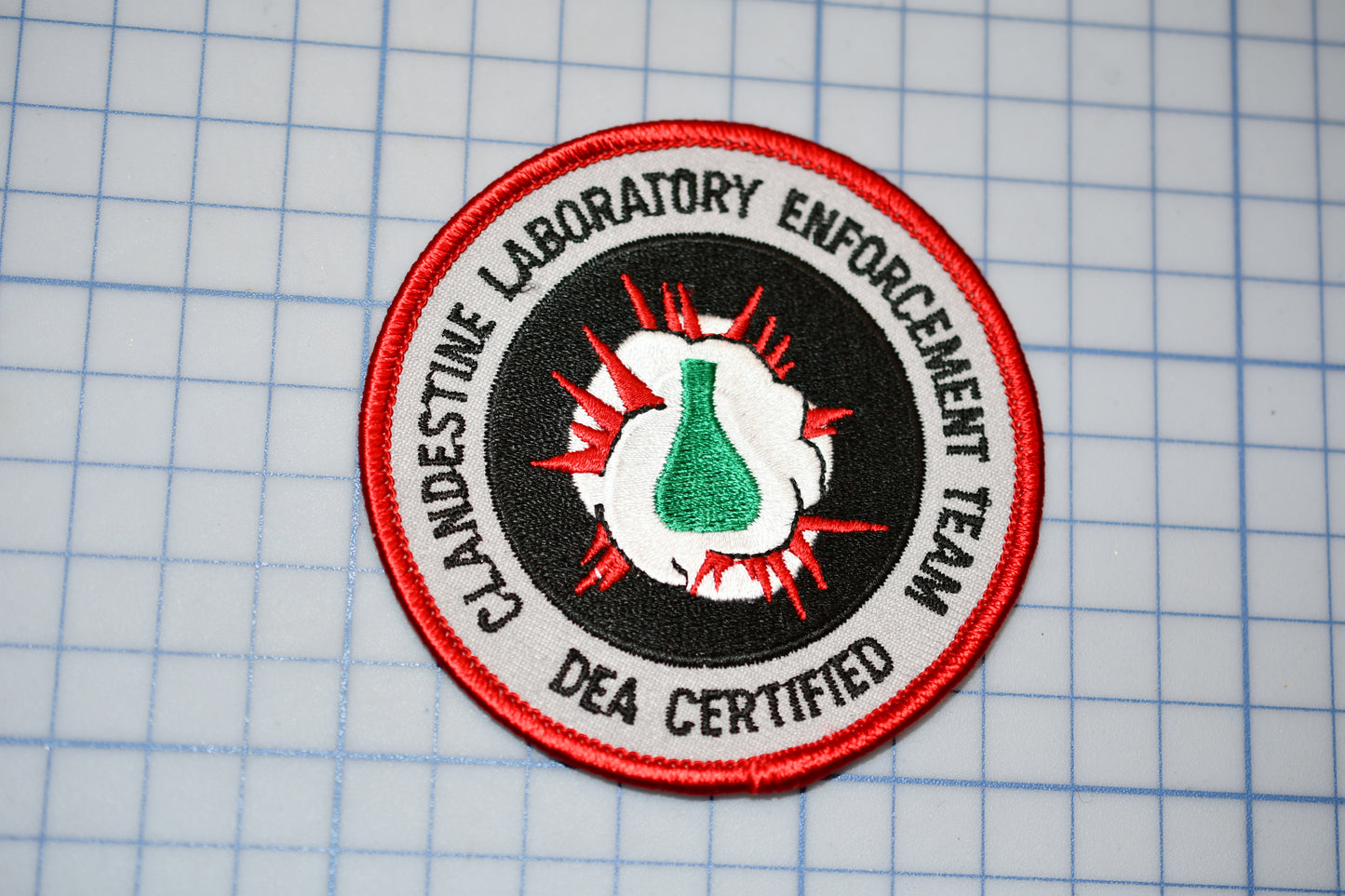 a red and black patch with a green beak on it