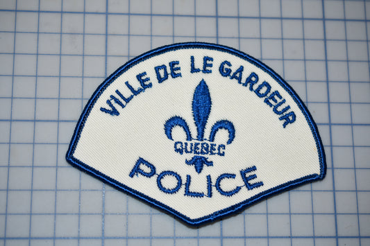 a police patch with a blue fleur de garde logo