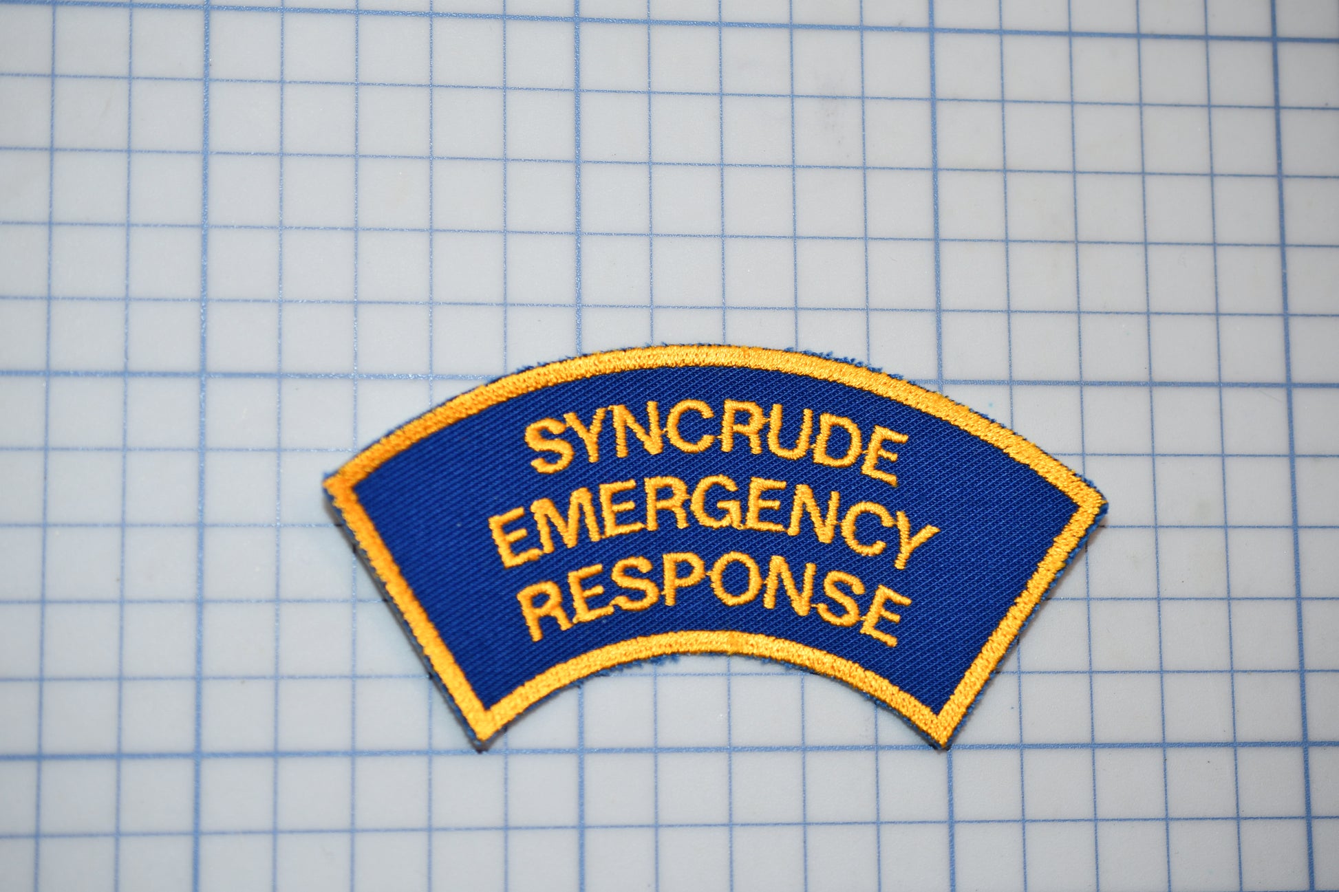 a blue and yellow patch with the words syncrude emergency response