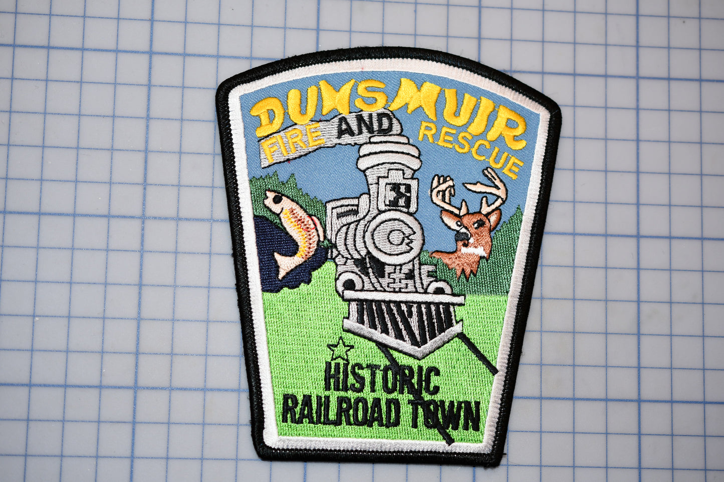 a patch with a train and deer on it