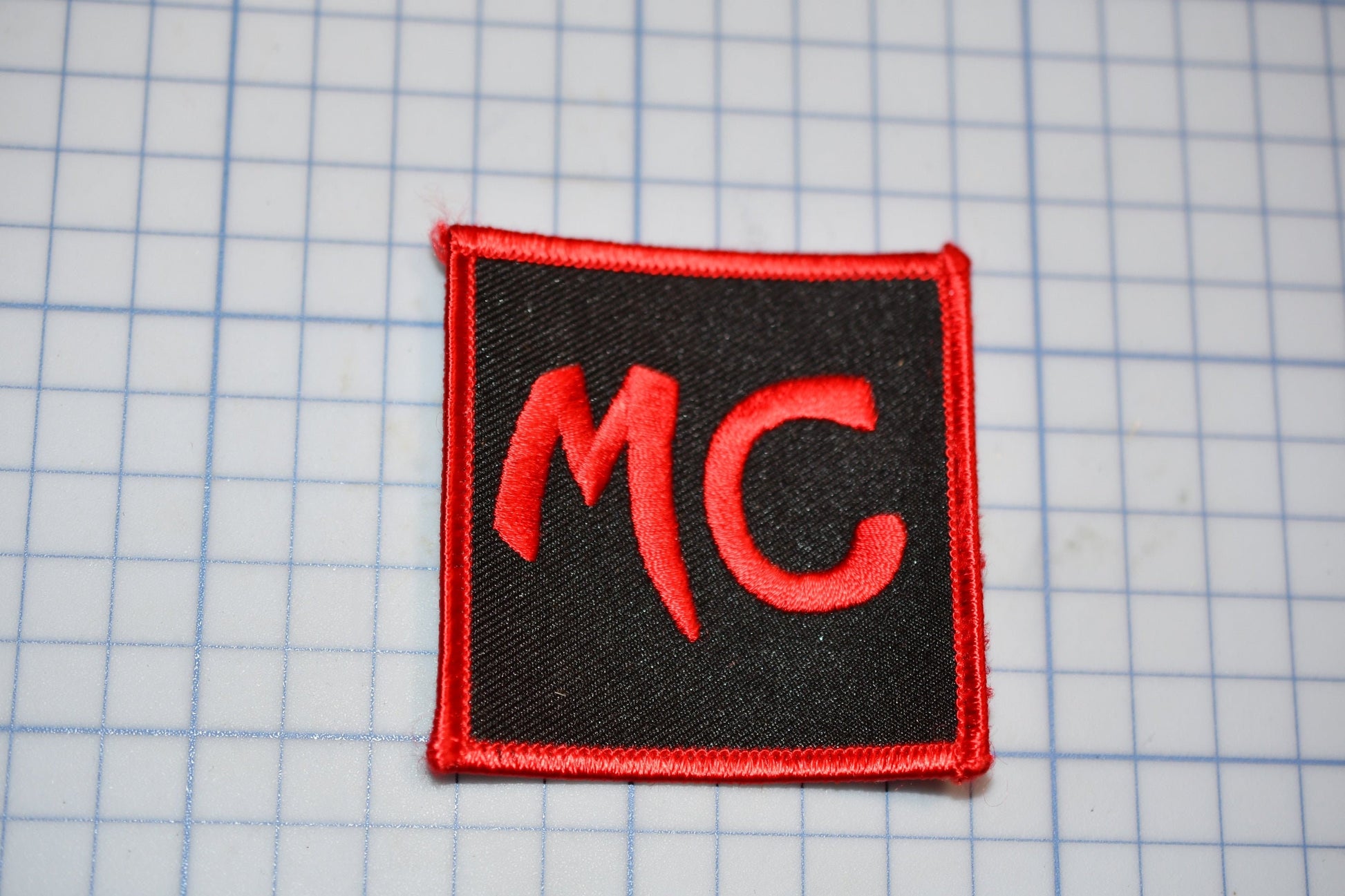 a red and black patch with the letter c on it